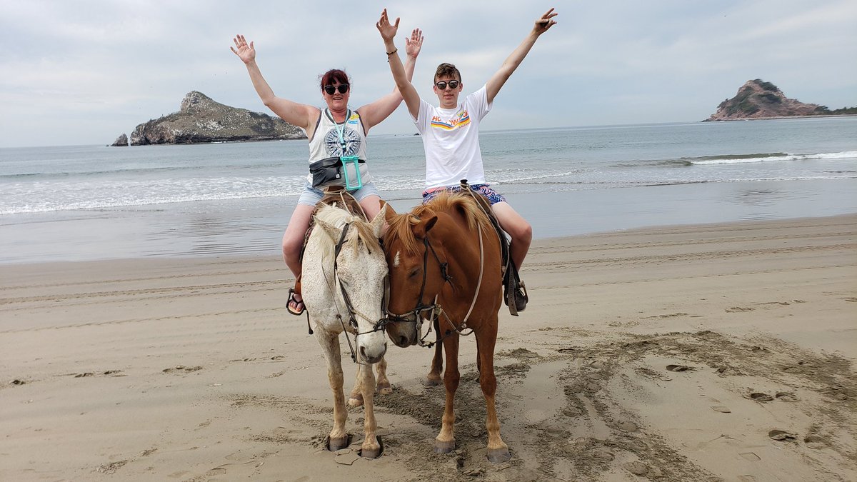 Horse riding along the shoreline sunset