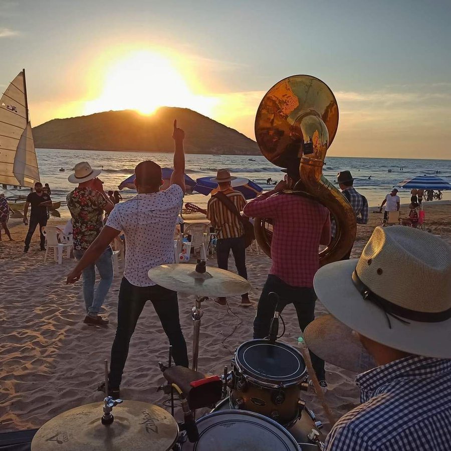 Traditional Sinaloan Banda musicians playing brass instruments on the sandy beaches of Mazatlán